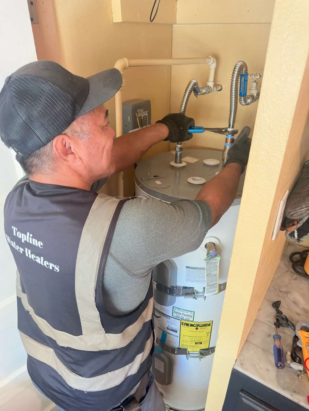 Joe Torculas of Topline Plumbing installing a water heater in Redding